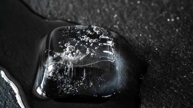 Time lapse of melting ice cubes on black background