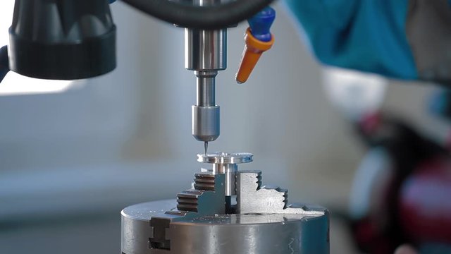 Milling machine with CNC cutting metal workpiece. Closeup milling cutter in work. Fine cut end mill shaving block of metal. CNC milling machine in operation high-tech machine lathe metal processing