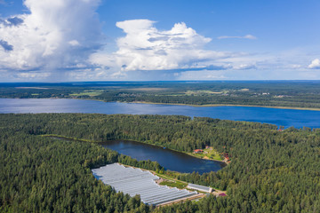 Aerial view of greenhouses by the lake in the forest