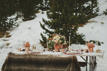 Close up of romantic wedding table in the middle of the mountain. Winter wedding decor.