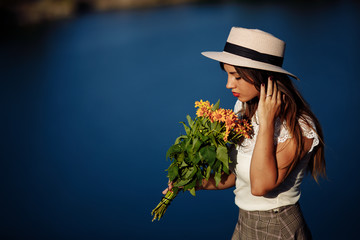 girl in a long dress with flowers on the background of a career lake