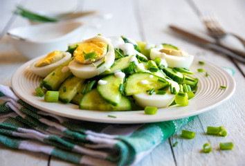 Healthy green salad with cucumbers, eggs and onions