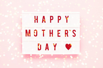 Fototapeta na wymiar HAPPY MOTHER'S DAY written in light box on pink background. Mother's Day celebration concept. Top view