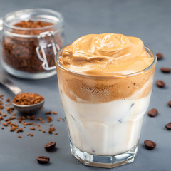 Dalgona coffee with ice, trendy korean drink on a dark gray background, square