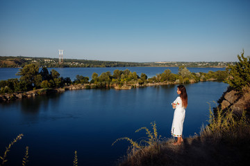 girl in a long dress on a background of water, lake career