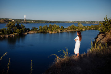girl in a long dress on a background of water, lake career