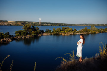 Obraz premium girl in a long dress on a background of water, lake career