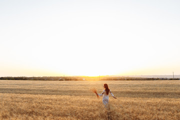 girl at sunset in a wheat field sky