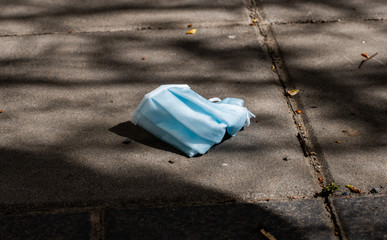 Stop Covid 19. The end of coronavirus. People discard surgical protective face mask on a public streets. Dirty used medical mask laying on the ground during an epidemic. Risk of disease, spread of