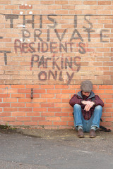 Fototapeta premium brick wall with writing on wall and man sitting against wall