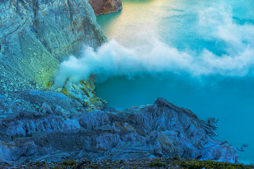 Looking down from edge of crater of the Kawah Ijen volcano. White smoke that coming from yellow...