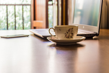 Laptop, cell phone and a tea cup on the desk, business from anywhere using computer and smartphone, mobile phone and pc - Image