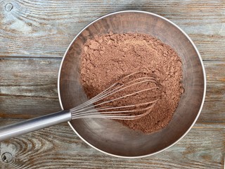 Dry mix of flour and sugar with cocoa, in a metal bowl ready for the recipe of chocolate cookies.
