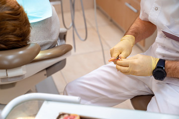 hands dentist adjust the size of the denture.