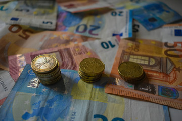 Euro coins forming a pyramid and banknotes superimposed on each other
