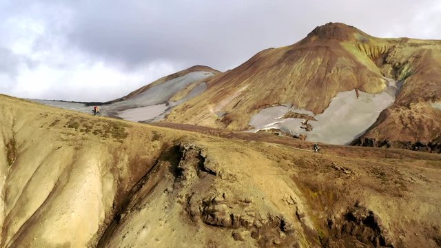 Amazing aerial drone shot of people riding on a path in Iceland