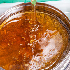 The process of extracting honey from bee honeycombs