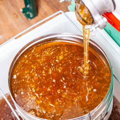 The process of extracting honey from bee honeycombs