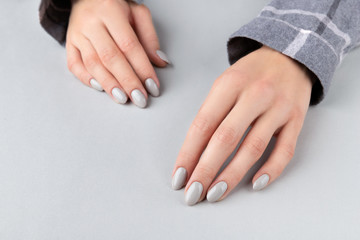 Beautiful womans hand with manicure in checkered shirt