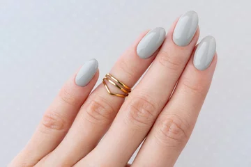 Beautiful womans hand with manicure close up on polka dot background