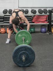 Fototapeta na wymiar Woman in the gym prepared to train weight training exercises