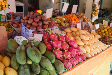 Fruit counter with mango, longan, dragon, mangosteen, lemons, tangerines in Thailand. Trade. Asia. Green diet