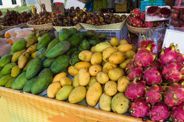 Fresh ripe mango and dragon are sold at a bazaar in Thailand. Asia. Fruits. Travel.