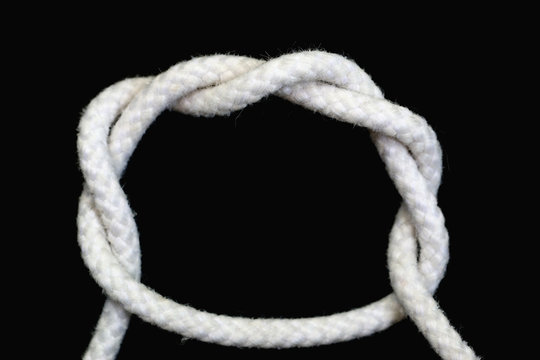 A white rope tied with double overhand knot on black background.