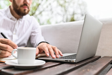 Young man using laptop at home. Closeup of man hands typing on computer indoor. Freelance, student lifestyle, education, technology and online shopping concept