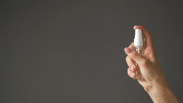 Doctor is a girl of Caucasian appearance holding an antiseptic in her hands and applying it on her hands