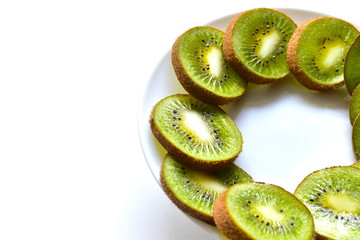 Kiwi fruit sliced on a snow white plate