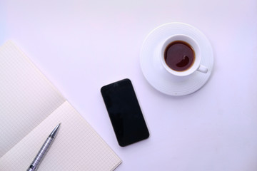 Fototapeta na wymiar smart phone, notepad and tea on white background 