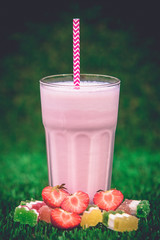 A strawberry milkshake glass on a table