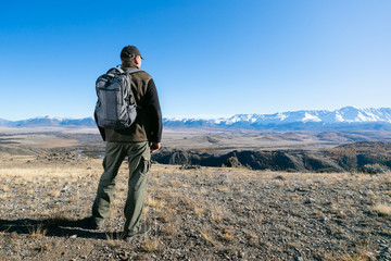 Man traveling with backpack hiking in mountains. Travel Lifestyle wanderlust adventure concept summer vacations outdoor