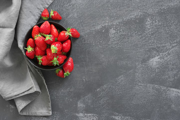 Fresh strawberries in bowl on grey