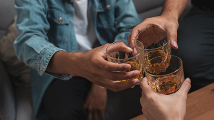 Alcoholic or party concept : Close up group of friend or colleague toasting glasses of alcohol whisky in pub or bar can use for party or celebrate concept.