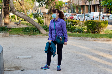 A woman in a medical mask in the Park