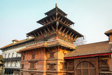 Obraz premium View of ancient hinduism Degutaleju Temple with brick walls and wooden carved statues on Kathmandu Durbar Square at the sunset. Religious architecture theme.