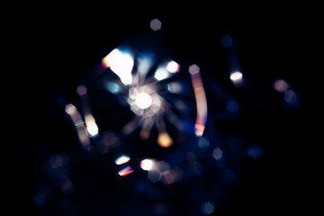 Abstract Shining bokeh lights glass rays on black background. Creative flash lens flare reflection...