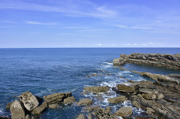 Fototapeta na wymiar views of the rocky shoreline on blue day
