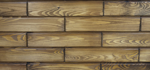 Dark brown horizontal short wood boards on the wall. Abstract Texture Background. Macro shooting, closeup