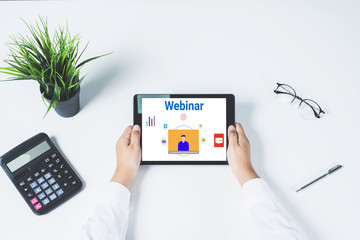 Doctor using a tablet computer for online training webinars. E-learning browsing connection and cloud online technology webcast concept. tablet mockup with clipping path on screen.