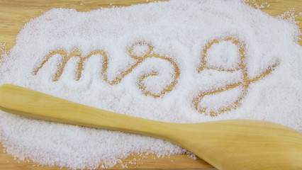 Monosodium glutamate(MSG) and spoon on wooden table. A flavour enhancer of many Thai food and asian food.