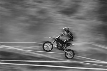 Naklejka na ściany i meble The motorcyclist is landing. Motocross. Sports. A moving blur background. B/w