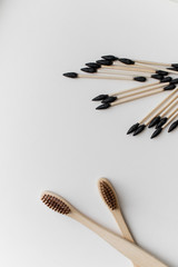 Biodegradable ear sticks and toothbrushes on a white background