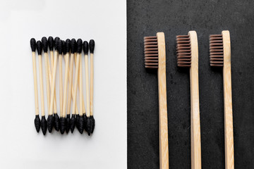 Biodegradable ear sticks and toothbrushes on a white and black background