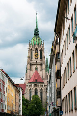 Fototapeta premium Bell tower of a church in Monaco of Bavaria. Check through the trees.