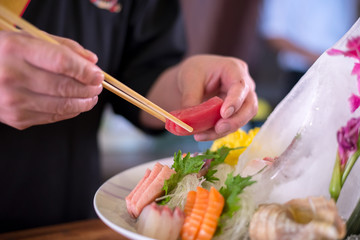 Obraz na płótnie Canvas Sushi chef making japanese dish sasimi