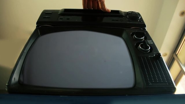 Male Hand putting VHS into VCR and an Old TV with Green Screen. You can replace green screen with the footage or picture you want. You can do it with “Keying” effect in After Effects.