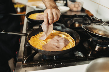 Professional chef working in restaurant kitchen and making delicious traditional food.